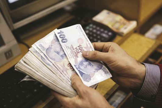 A money changer counts Turkish lira bills at a currency exchange office in central Istanbul. The currency has dropped as much as 10% since the start of 2017.