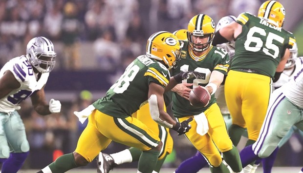 Aaron Rodgers (C) of the Green Bay Packers hands off to Ty Montgomery (R) during the third quarter in the NFC Divisional Playoff game at AT&T Stadium in Arlington, Texas. (AFP)