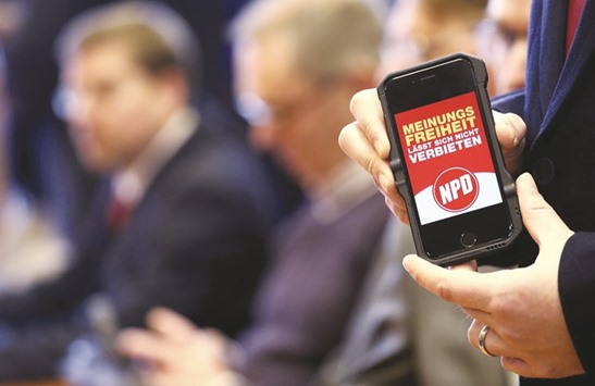 A member of the NPD shows a cellphone with the slogan u2018freedom of speech canu2019t be bannedu2019 after the Constitutional Court threw out an attempt by the countryu2019s 16 federal states to ban the far-right party.
