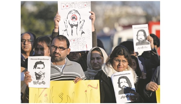 Pakistani activists hold images of bloggers who have disappeared, during a protest in Islamabad.
