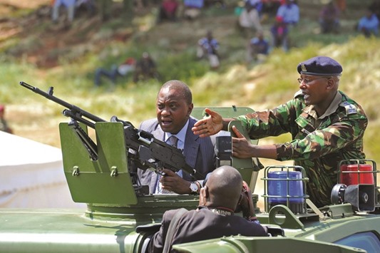 Kenyan President Uhuru Kenyatta stands inside an armoured personal carrier during the commissioning of 500 police vehicles at Nairobiu2019s Uhuru Park. Kenyatta said the armoured personal carriers will help Kenyan police to counter the terrorism in the country.