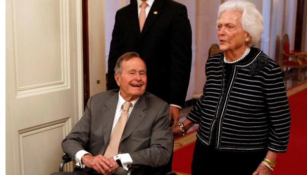 Former US President George H. W. Bush (L) and former first lady Barbara Bush enter the East Room of the White House before the ceremony unveiling the official White House portraits of former President George W. Bush and former first lady Laura Bush in the East Room of the White House in Washington in this file image from May 31, 2012.