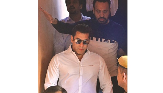 Bollywood actor Salman Khan walks with officials as he leaves after a court appearance in Jodhpur yesterday.