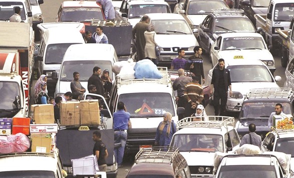 People walk at a market amidst a traffic jam in downtown Cairo (file). Egypt will scrap its remaining caps on transfers and deposits of foreign currency by the end of June and overhaul its oil sector as part of ambitious efforts to reform the economy under an IMF agreement, the details of which were released yesterday.