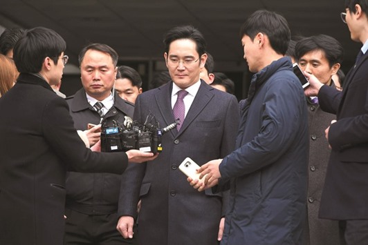 Samsung Group chief Jay Y Lee (centre) leaves for a waiting facility after attending a court hearing on whether he will be issued with an arrest warrant at the Seoul Central District Court in Seoul yesterday.