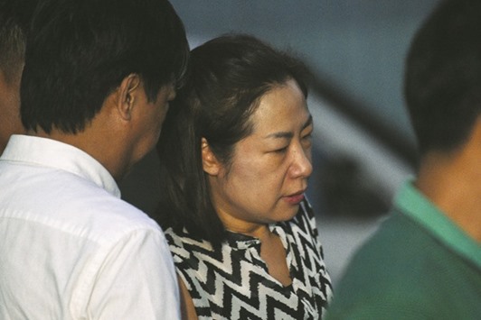 The wife of a South Korean businessman, who was kidnapped and murdered by at least three police officers in the Philippines, is escorted by agents as she leaves the National Bureau of Investigation (NBI) headquarters after holding talks in Manila yesterday.
