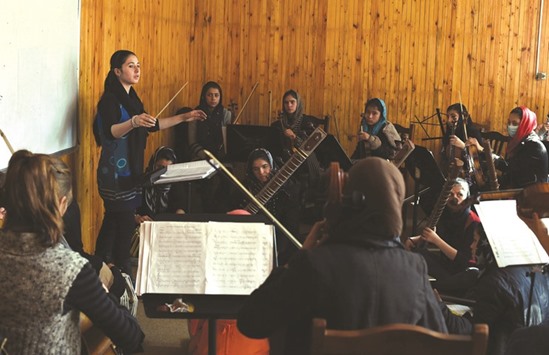 19-year-old Afghan Negina Khpalwak (left), the first female orchestra conductor in Afghanistan, conducts her musicians during a rehearsal at The Afghanistan National Institute of Music in Kabul.