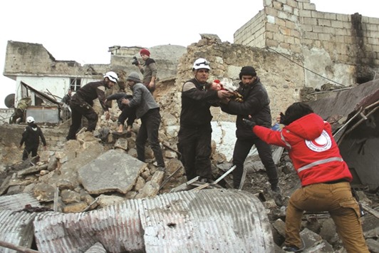 Syrian Civil Defence volunteers, also known as the White Helmets, rescue children from a damaged building following a reported air strike that targeted the Idlib bus station yesterday.