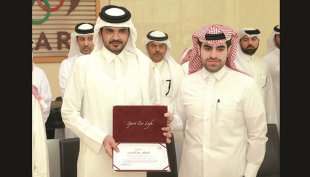 Qatar Olympic Committee (QOC) president HE Sheikh Joaan bin Hamad al-Thani (left) honours a scholarship graduate at a ceremony held on the sidelines of the QOCu2019s General Assembly meeting.
