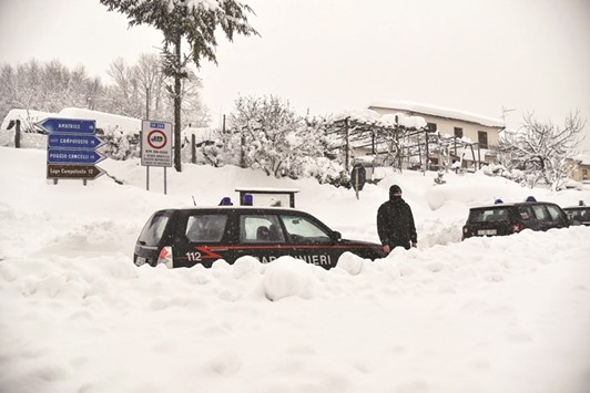 Italian Carabinieri vehicles wait in the snow of a central street of Aringo near Monterale, after a 5.7-magnitude earthquake struck the region, yesterday.