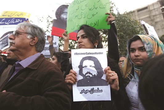 Human rights activists hold a picture of Salman Haider, who is missing, during a protest to condemn the disappearances of social activists in Karachi.