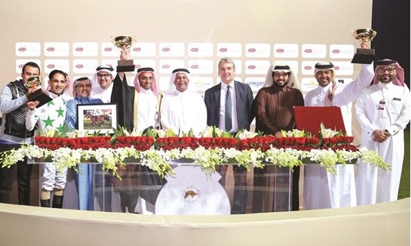HE Abdullah bin Hamad al-Attiyah and Qatar Racing and Equestrian Club (QREC) general manager Nasser Sherida al-Kaabi with the winners of the HE Abdullah bin Hamad al-Attiyah Cup after Meqdam Al Zaidy won the 2,000m race at the QREC yesterday. PICTURE: Juhaim