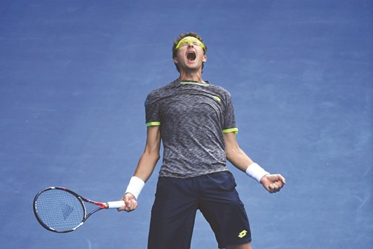 Denis Istomin celebrates after sending defending champ Novak Djokovic packing in Melbourne.