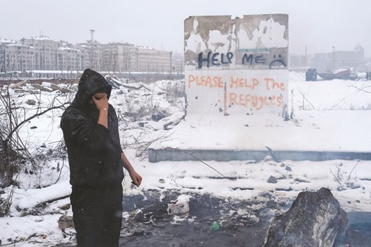 A migrant breaks down outside of a derelict customs warehouse in Belgrade.
