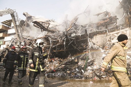 Iranian emergency personnel search for victims through the wreckage of the Plasco building.