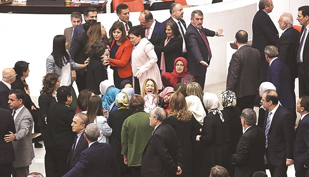 Ruling AK Party and opposition lawmakers scuffle after Turkish deputy Aylin Nazliaka (centre) handcuffed herself to the podium in a protest against the constitutional reform aimed at strengthening the powers of the Turkish president.