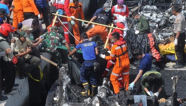 Rescuers remove the bodies of victims from a passenger boat which caught fire while sailing from Jakarta to Tidung island, in Jakarta on Sunday.