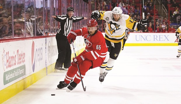 Pittsburgh Penguins forward Bryan Rust (right) tries to slip the puck past Carolina Hurricanes defensemen Ron Hainsey during the third period of the NHL game at PNC Arena. (USA TODAY Sports)