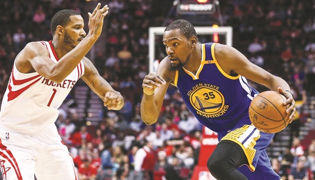 Golden State Warriors forward Kevin Durant (right) dribbles the ball as Houston Rockets forward Trevor Ariza defends during the third quarter of the NBA match at the Toyota Center in Houston, Texas on Friday. (USA TODAY Sports)