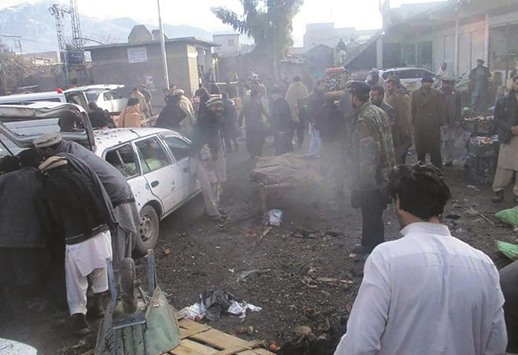 Pakistani security officials and local residents gather at the site of a bomb explosion at a vegetable market in Parachinar city, the capital of Kurram tribal district on the Afghan border on yesterday.