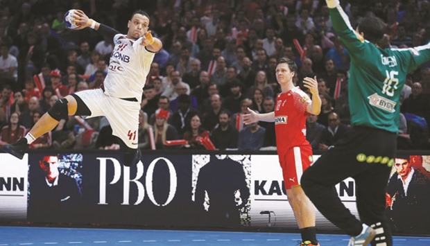 Qataru2019s pivot Youssef Ali (L) jumps to shoot on goal as Denmarku2019s goalkeeper Jannick Green Krejberg (R) stretches out during their 25th IHF Menu2019s World Championship 2017 Group D handball match at the Accorhotels Arena in Paris on Friday.  At right, Denmark fans cheer.