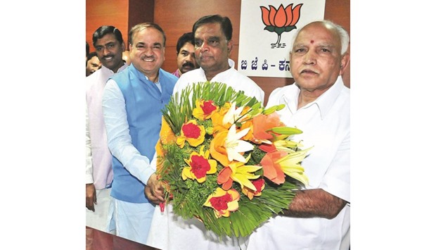 Former Congress leader V Srinivas Prasad is congratulated by BJP Karnataka chief B S Yeddiyurappa in Bengaluru yesterday.