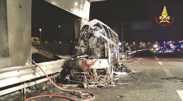 This handout photo shows a firefighter extinguishing flames in the wreckage of the bus following the crash on the A4 motorway near the Verona East exit, northern Italy.