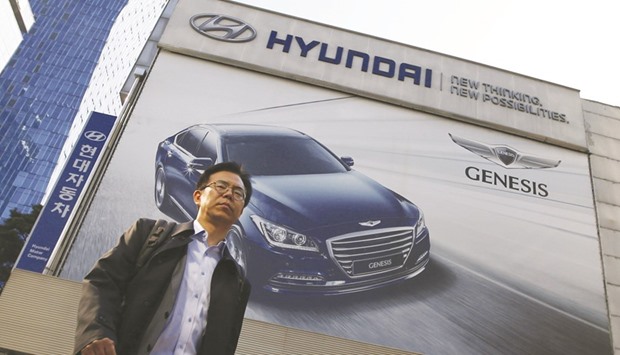 A man walks past a Hyundai dealership in Seoul. Hyundai and Kia Motors forecast sales to climb 4.7% this year as they count on new model introductions to counter intensifying competition amid global uncertainties.