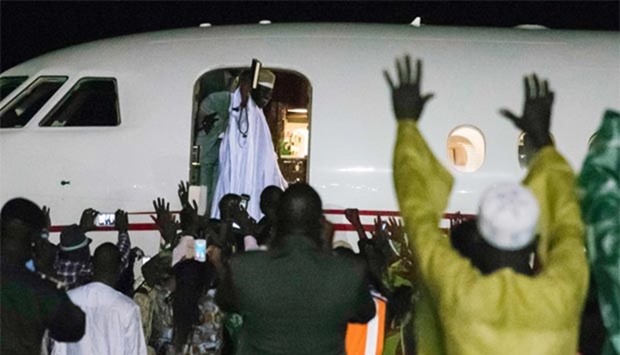 Former president Yahya Jammeh, Gambia's leader for 22 years, waves from the plane as he leaves the country on Saturday in Banjul.