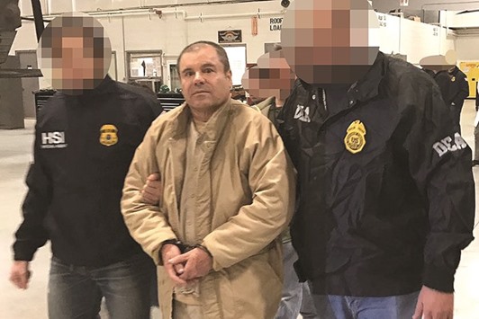 TOPSHOT - This handout picture released by the Mexican Interior Ministry on January 19, 2017 shows Joaquin Guzman Loera aka u201cEl Chapou201d Guzman (C) escorted in Ciudad Juarez by the Mexican police as he is extradited to the United States.