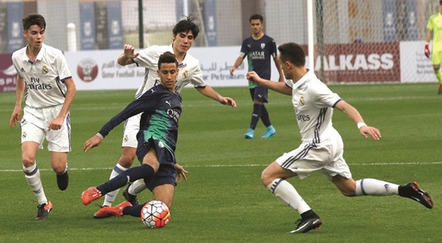 An Al Ahli player (in blue) vies for the ball with Real Madrid (in white) players during their match yesterday. PICTURE: Jayaram