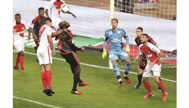 Monacou2019s Colombian forward Radamel Falcao (left) and Alhassan Wakaso of Lorient go for a header during the French Ligue 1 match in Monaco yesterday. (AFP)