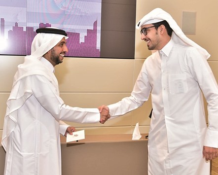 A scholar shakes hands with QU president Dr Hassan al-Derham at the ceremony.