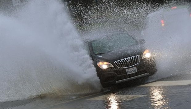 Cars pass through a flooded section of road as the strongest storm of the season hits Los Angeles on Sunday.