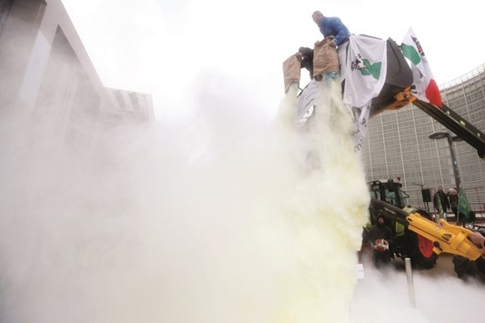 Milk producers spray powdered milk to protest dairy market overcapacity, outside a meeting of European Union agriculture ministers in Brussels.