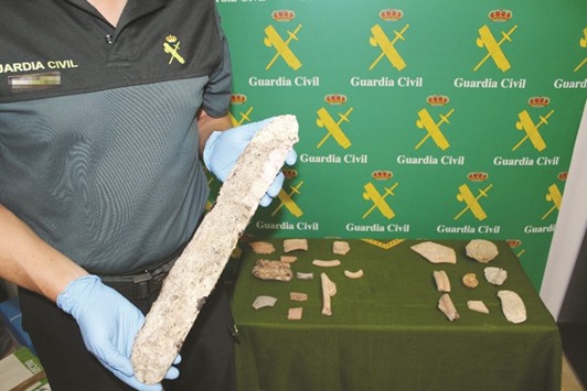 A handout picture released yesterday by Spanish Guardia Civil shows a police officer displaying a piece of archaeology recovered during a joint operation. Police from 18 European countries recovered more than 3,500 stolen works of art and ancient artefacts, some of u2018great cultural importanceu2019.