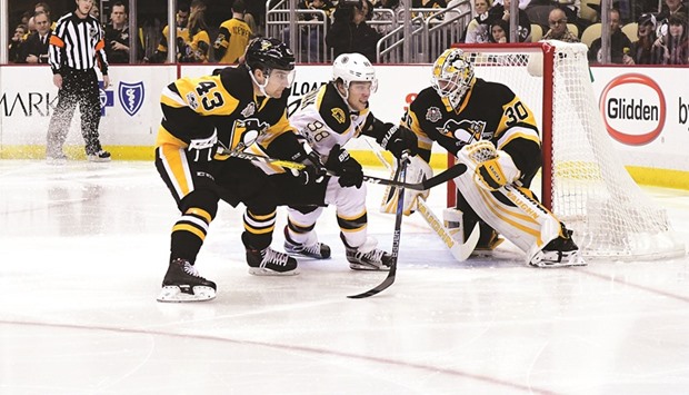 Conor Sheary (left) of the Pittsburgh Penguins fights for position against David Pastrnak (centre) of the Boston Bruins while Matt Murray (right) defends during the NHL game at PPG PAINTS Arena in Pittsburgh, Pennsylvania, on Sunday. (AFP)