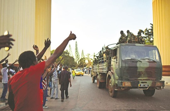 Gambians cheer Senegalese soldiers as they arrive at the Statehouse in Banjul.