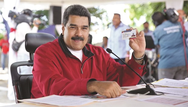 Venezuelan President Nicolas Maduro holds up the the new u2018Homeland Cardu2019 in Caracas. The card entitles the holder to avail of state social programme benefits.