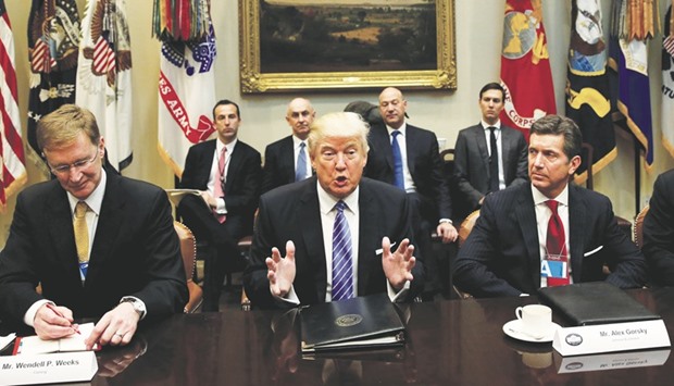 US President Donald Trump hosts a meeting with business leaders in the Roosevelt Room of the White House in Washington as Corning CEO Wendell Weeks (left) and Johnson & Johnson CEO Alex Gorsky look on.
