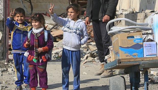 Children flash victory signs to Iraqi army soldiers during a fight with Islamic State militants north of Mosul.