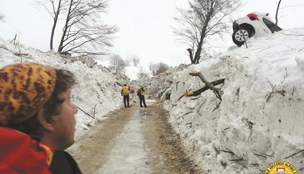 Rescue workers inspect a cleared road by the site of the Hotel Rigopiano in Farindola, central Italy.