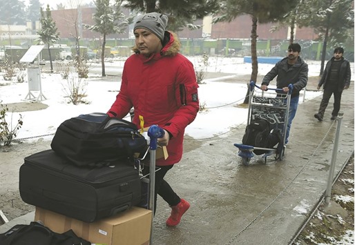 Afghan refugees who have been deported from Germany arrive with their belongings at the international airport in Kabul yesterday.
