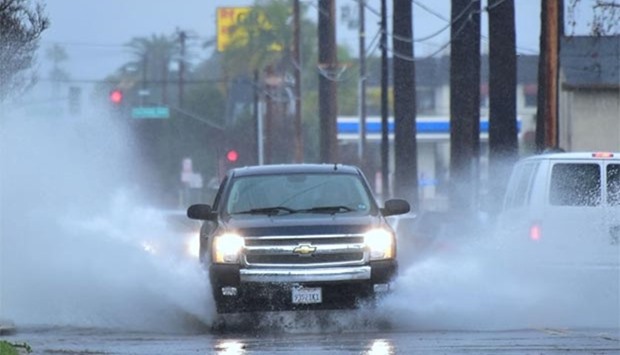 A vehicle is driven along a lightly flooded street in Monterey Park, California on Monday.