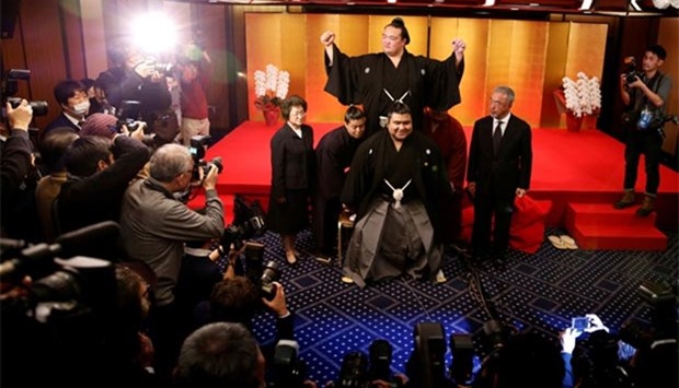 Japanese sumo wrestler Kisenosato (top centre) raises his arms as he is hoisted up by his stable's sumo wrestlers in celebration of his promotion to Yokozuna, or grand champion, after a ceremony in Tokyo on Wednesday.