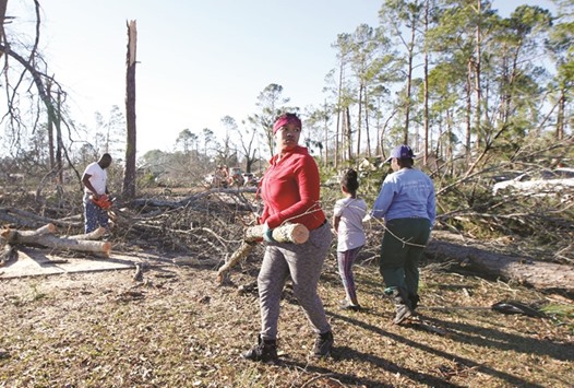Locals clear debris away from their home after a tornado ripped through the area in Albany, Georgia.