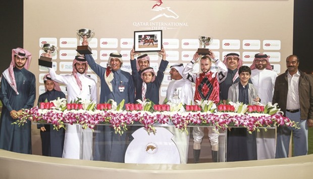 Qatar Racing and Equestrian Club vice-chief steward Abdulla Rashid al-Kubaisi (centre) with the winners of the Umm Al Houl Cup after Lupie won the 1200m run at QREC yesterday. PICTURES: Juhaim
