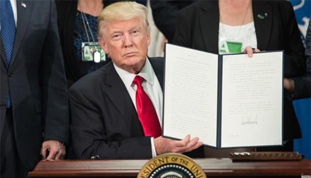 President Donald Trump signs an executive order to start the Mexico border wall project.