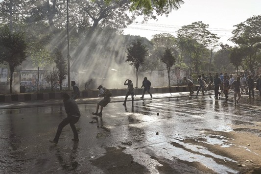 Bangladeshi activists throw stones towards police during a protest against the construction of a coal-fired power plant.