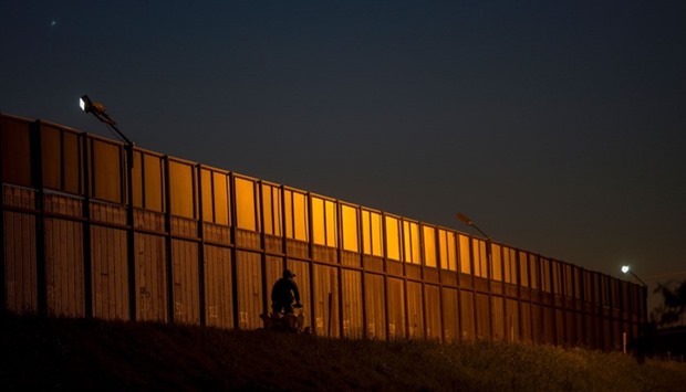 A border patrol agent drives along the US- Mexico border crossing in San Ysidro, California